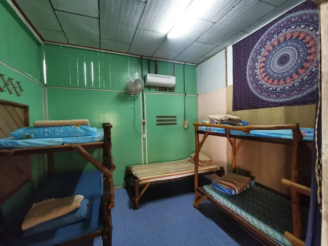 Wooden bunk beds with blue bedding in the Aguna Resort dorm room