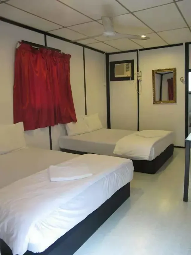 Two queen beds, air conditioning and a ceiling fan in an Aguna Resort quad room