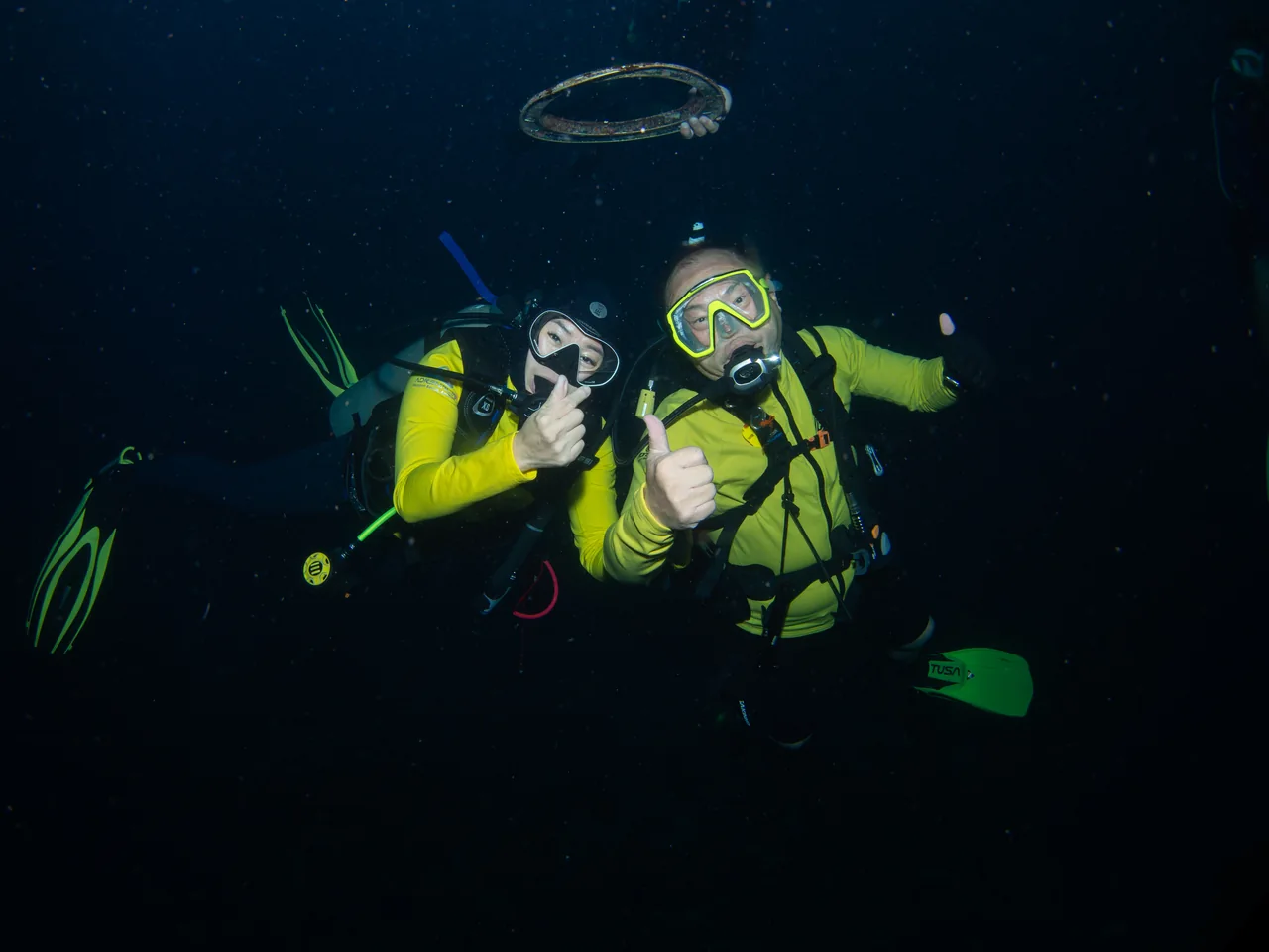 Two divers beneath an underwater bubble ring