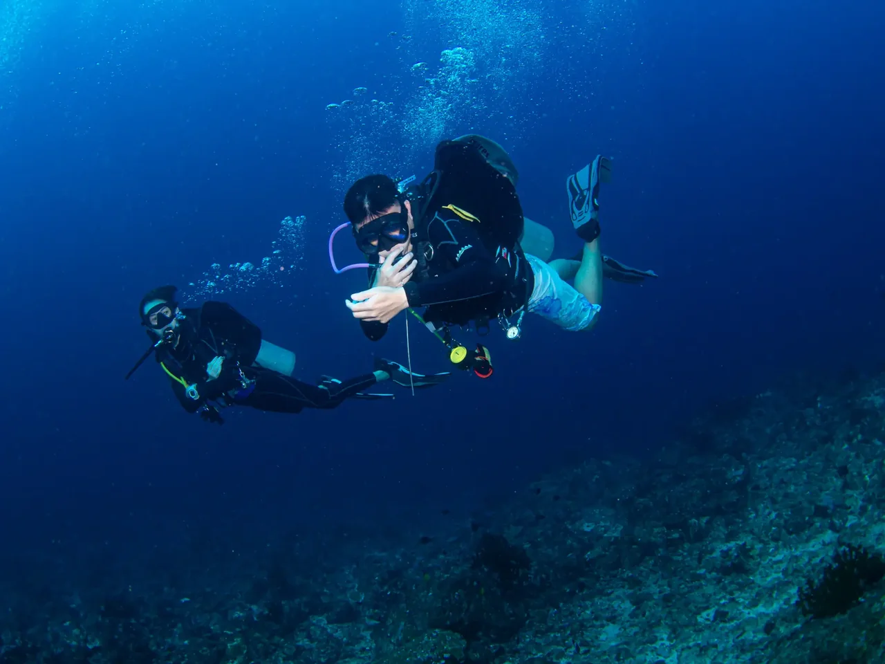 Scuba divers swimming together above a reef during Divemaster training