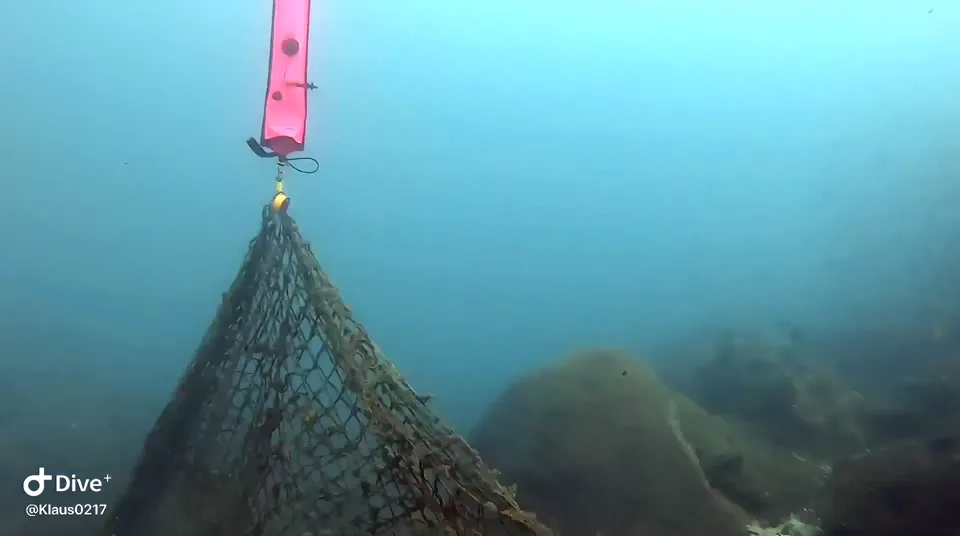 A ghost net being lifted underwater, from the Project AWARE film